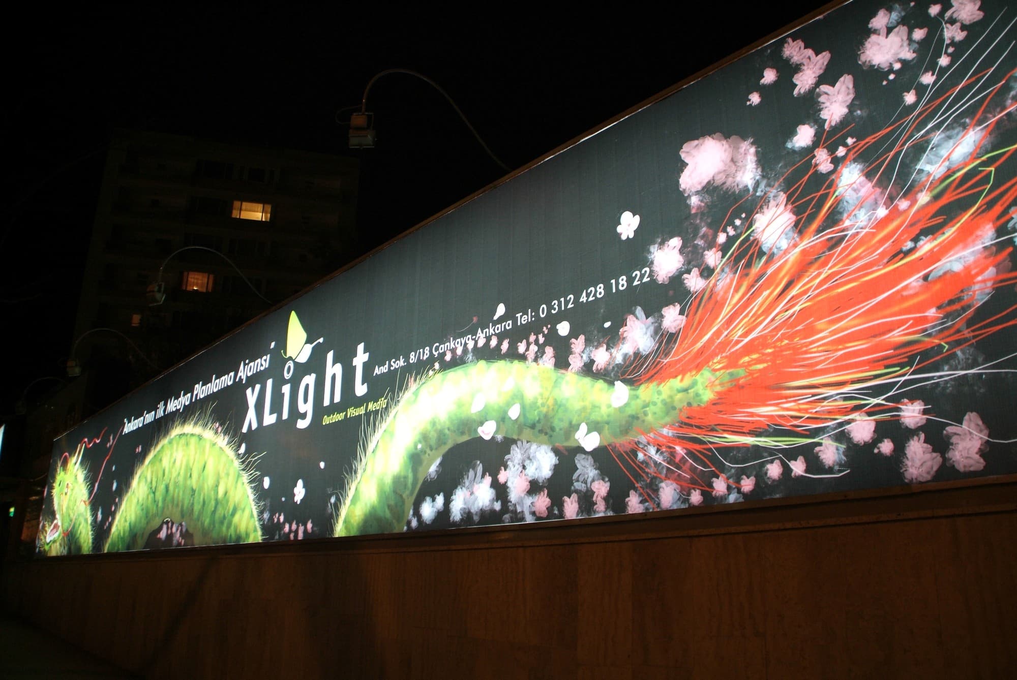 Gece aydınlatmalı XLight panosu: yeşil ejder illüstrasyonu ve XLight logosu, Ankara (arşiv, 2006)